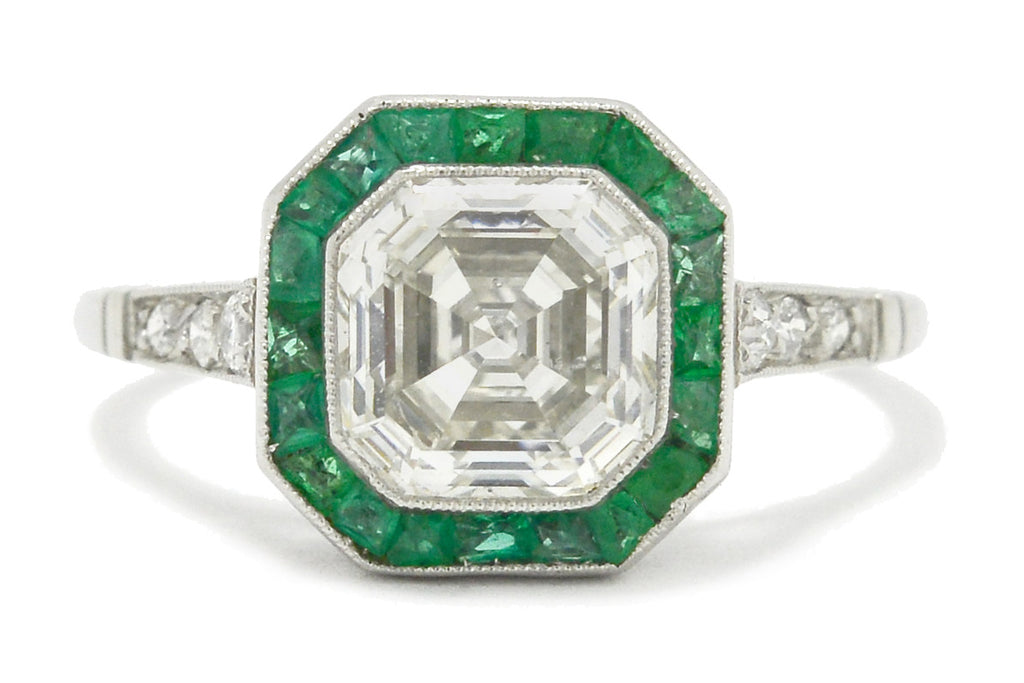 An Art Deco style platinum diamonds engagement ring with emeralds.