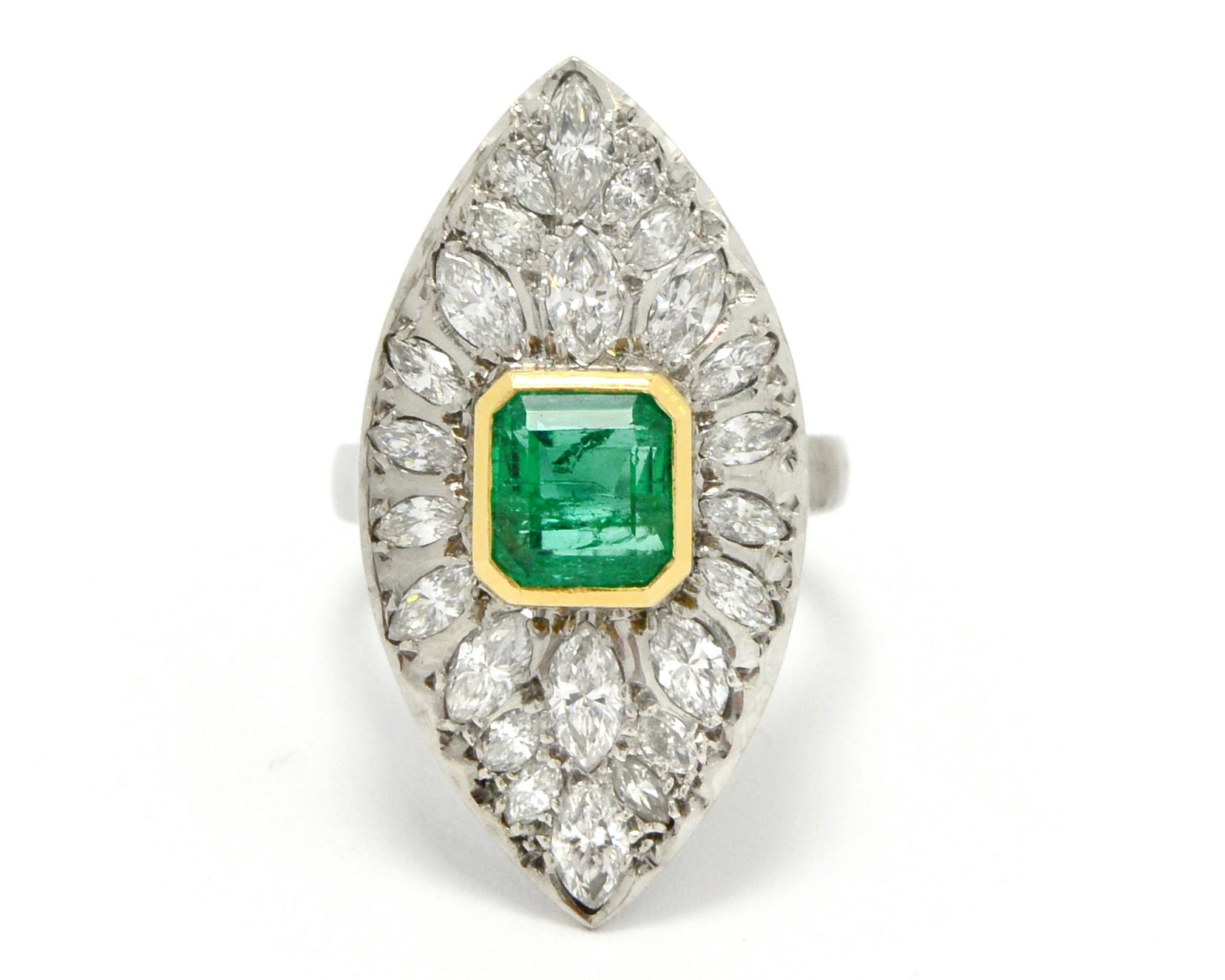 A stunning retro era estate cluster ring featuring a 2 carat Colombian emerald.