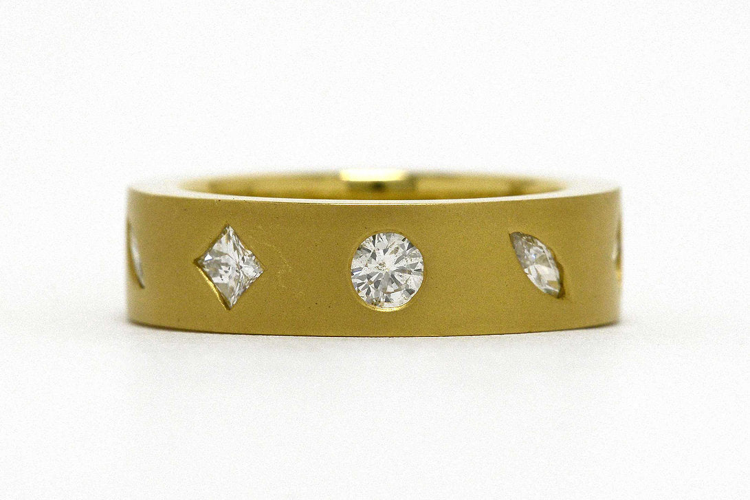 Round, princess and marquise diamonds set in a modern, 18k gold band.