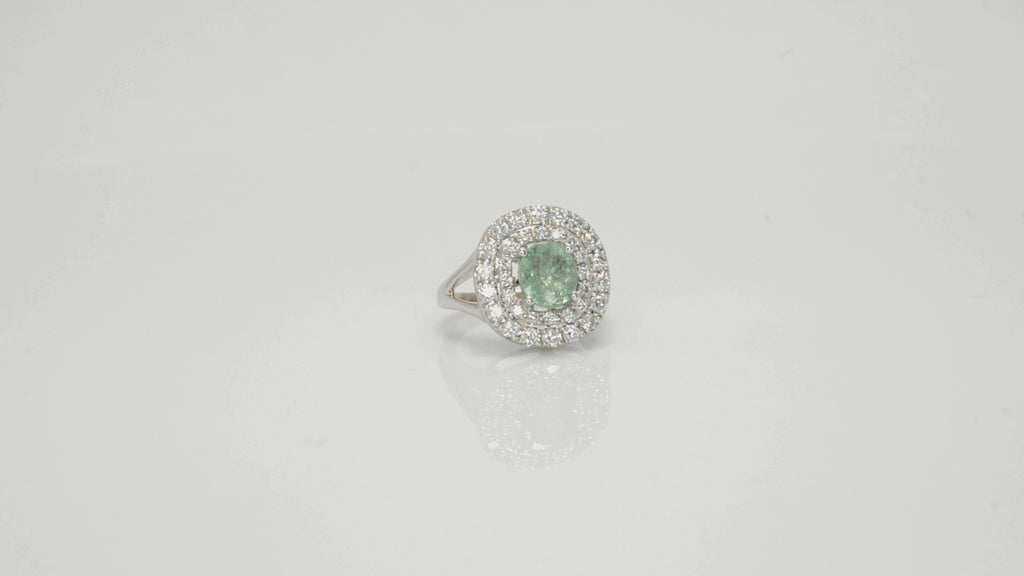 A sparkling cushion cut, natural paraiba tourmaline ring surrounded by 2 halos of diamonds.