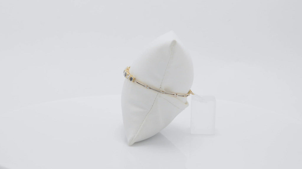A platinum and 18k yellow gold blue sapphire and diamonds line bracelet.