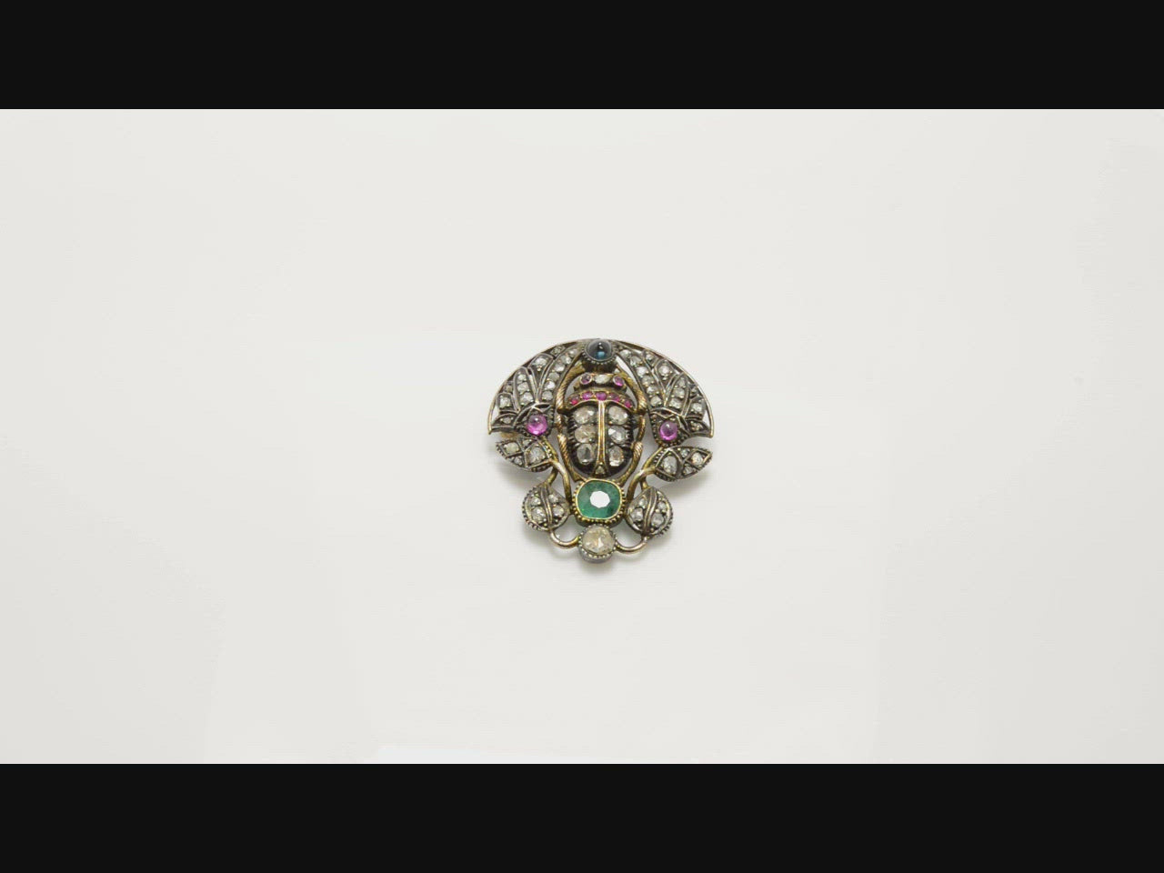 A Victorian, late 1800s silver scarab beetle brooch with gold accents.