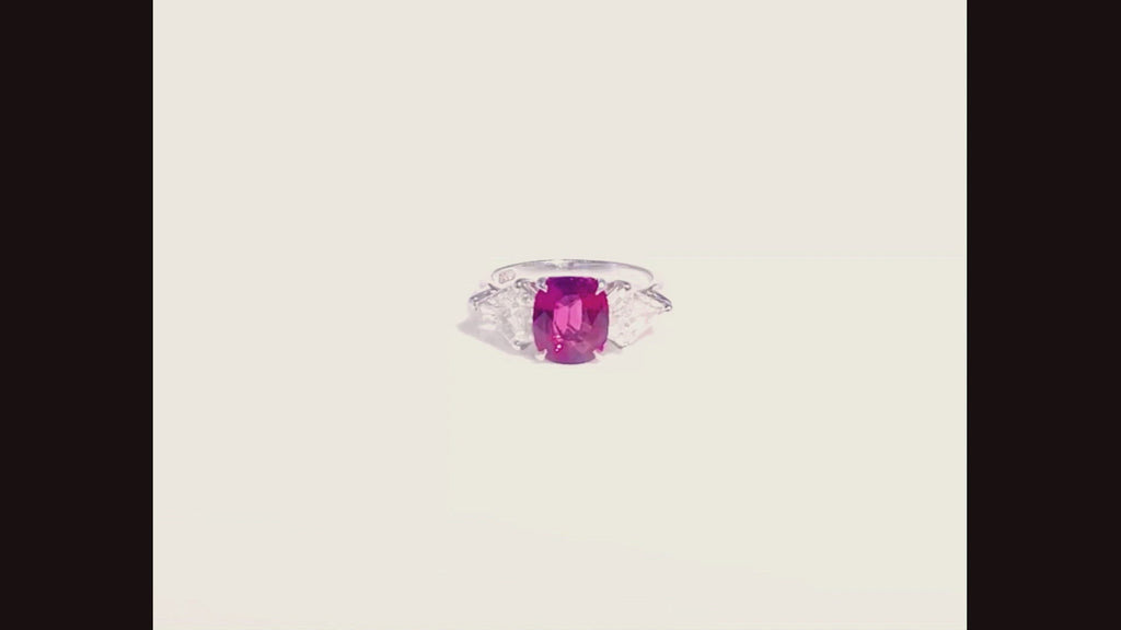 Vivid pink purple color is shown in this stunning three gemstone engagement ring.