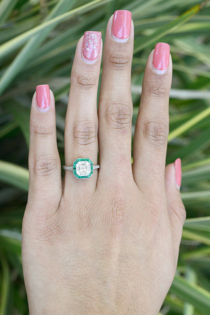 A two carat asscher cut diamond octagon engagement ring with emeralds.