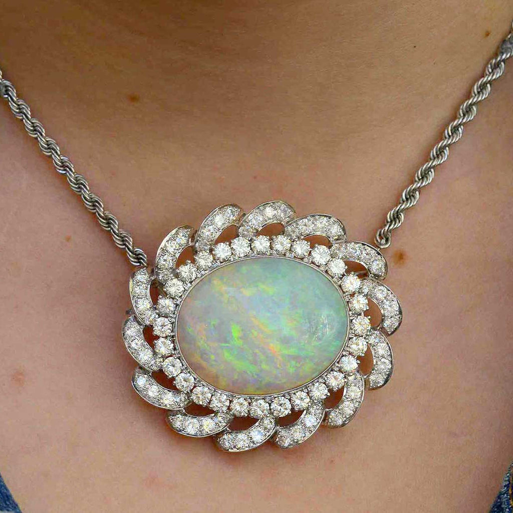This cabochon oval opal is set in a diamond halo statement necklace.