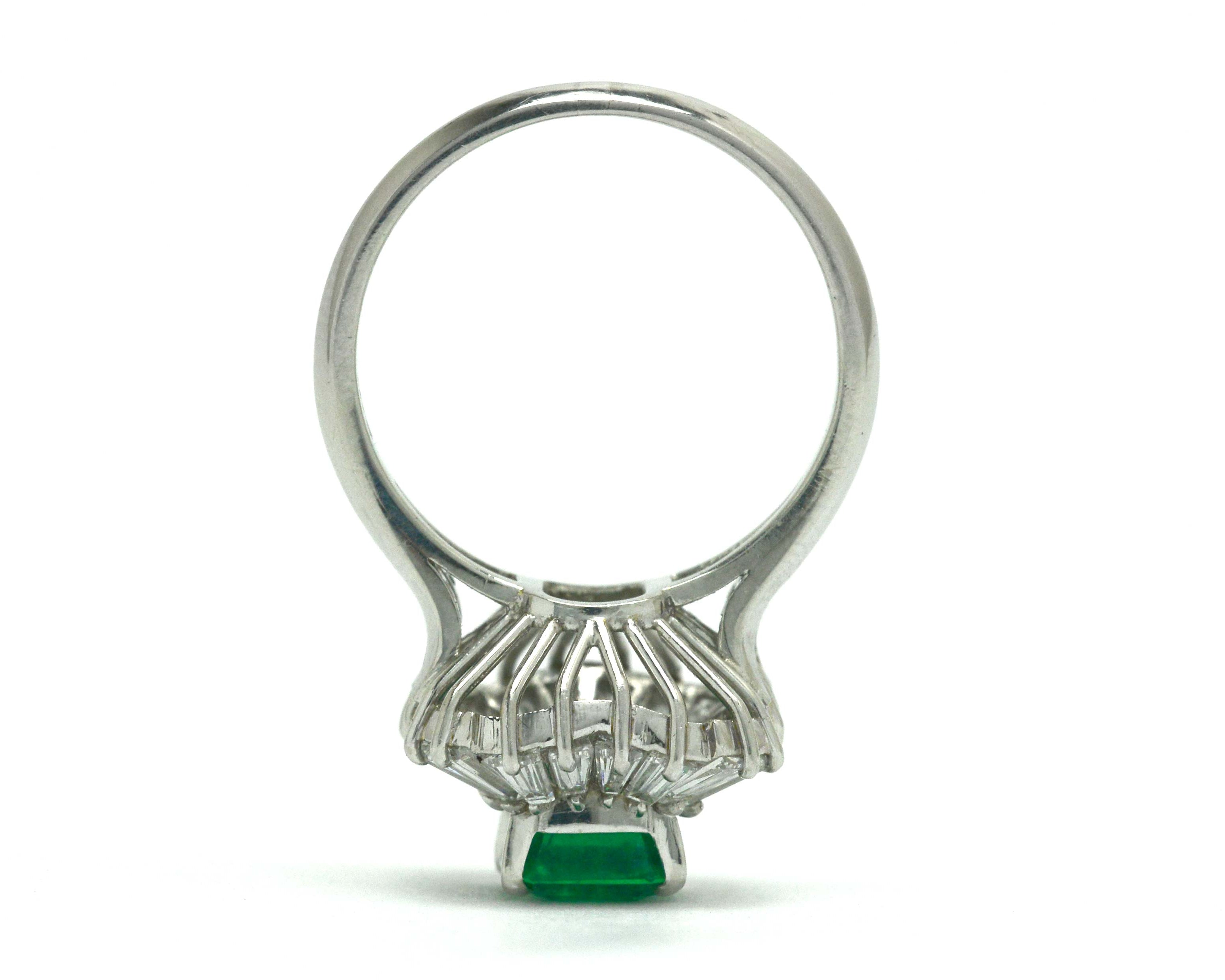 Baguette diamonds accent the 1 and half carat emerald in this platinum ballerina ring.