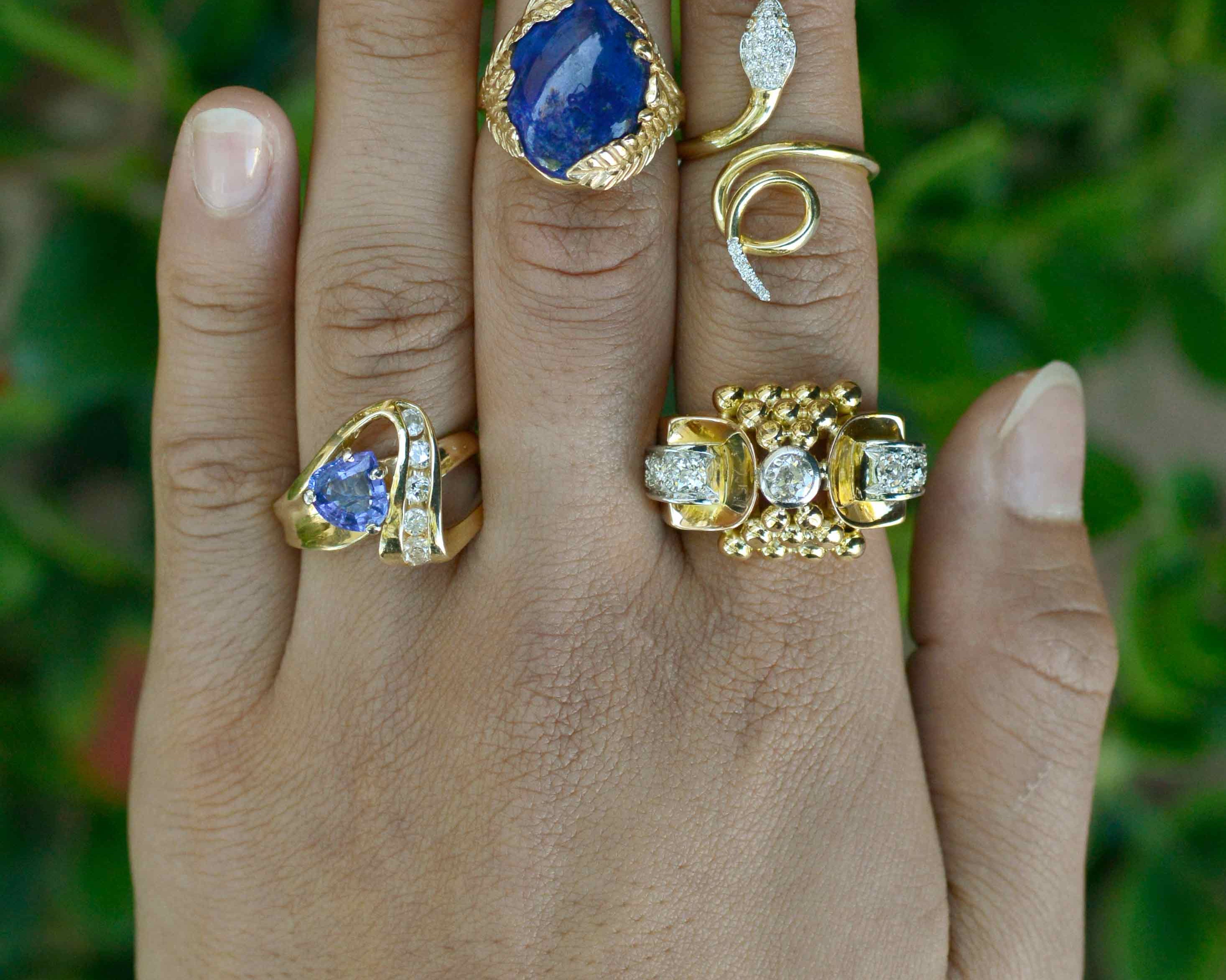 Modern gold cocktail rings set with diamonds and blue gemstones.