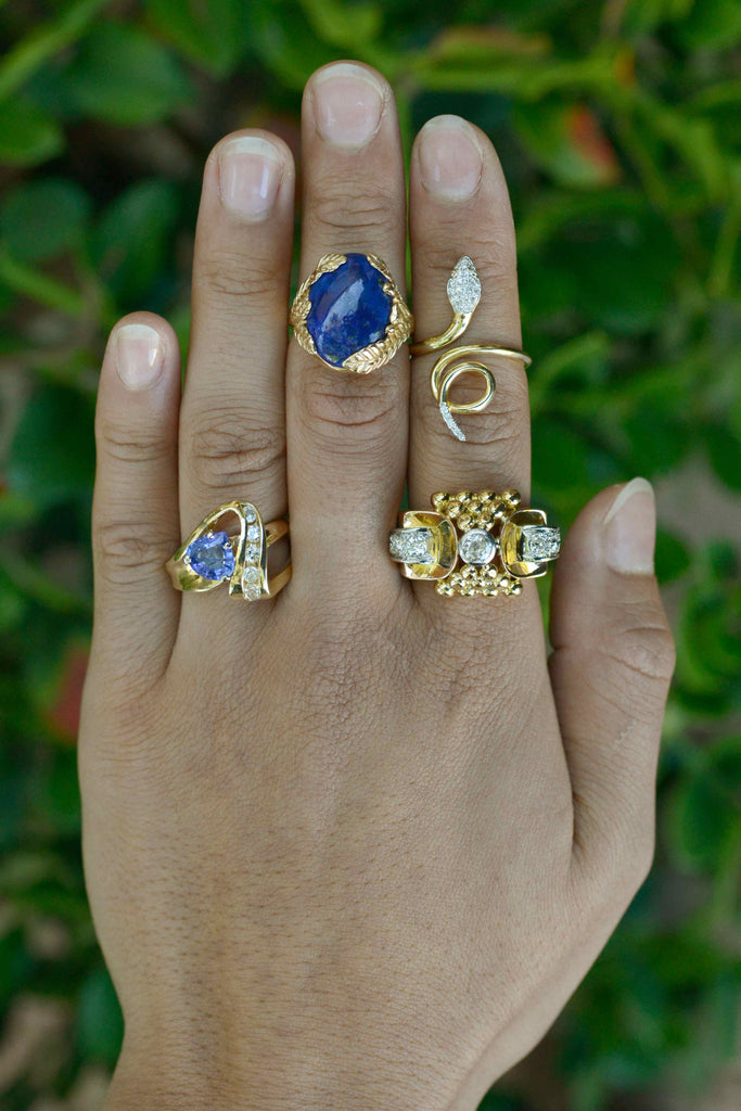 Modern gold cocktail rings set with diamonds and blue gemstones.