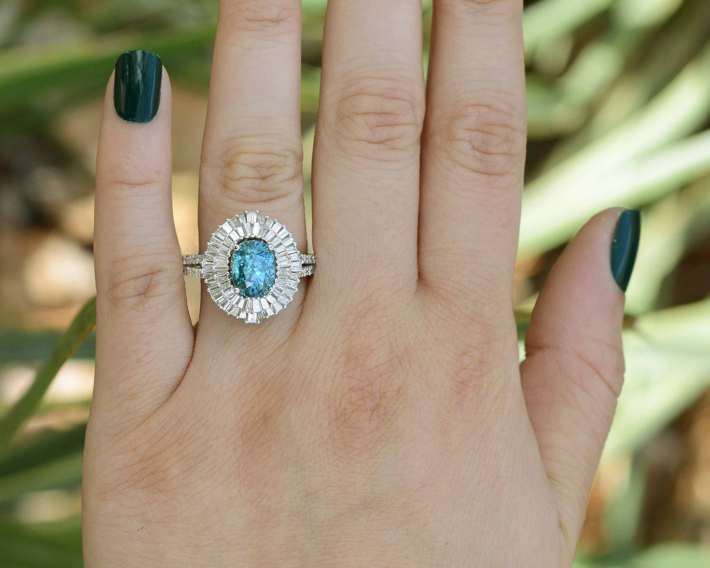 An 18k white gold blue zircon ring with double diamond halo.