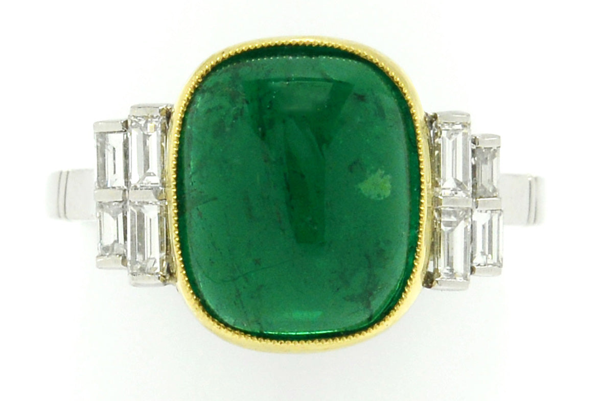 A highly-transparent, vivid green emerald set in a ring with 8 diamond accents.