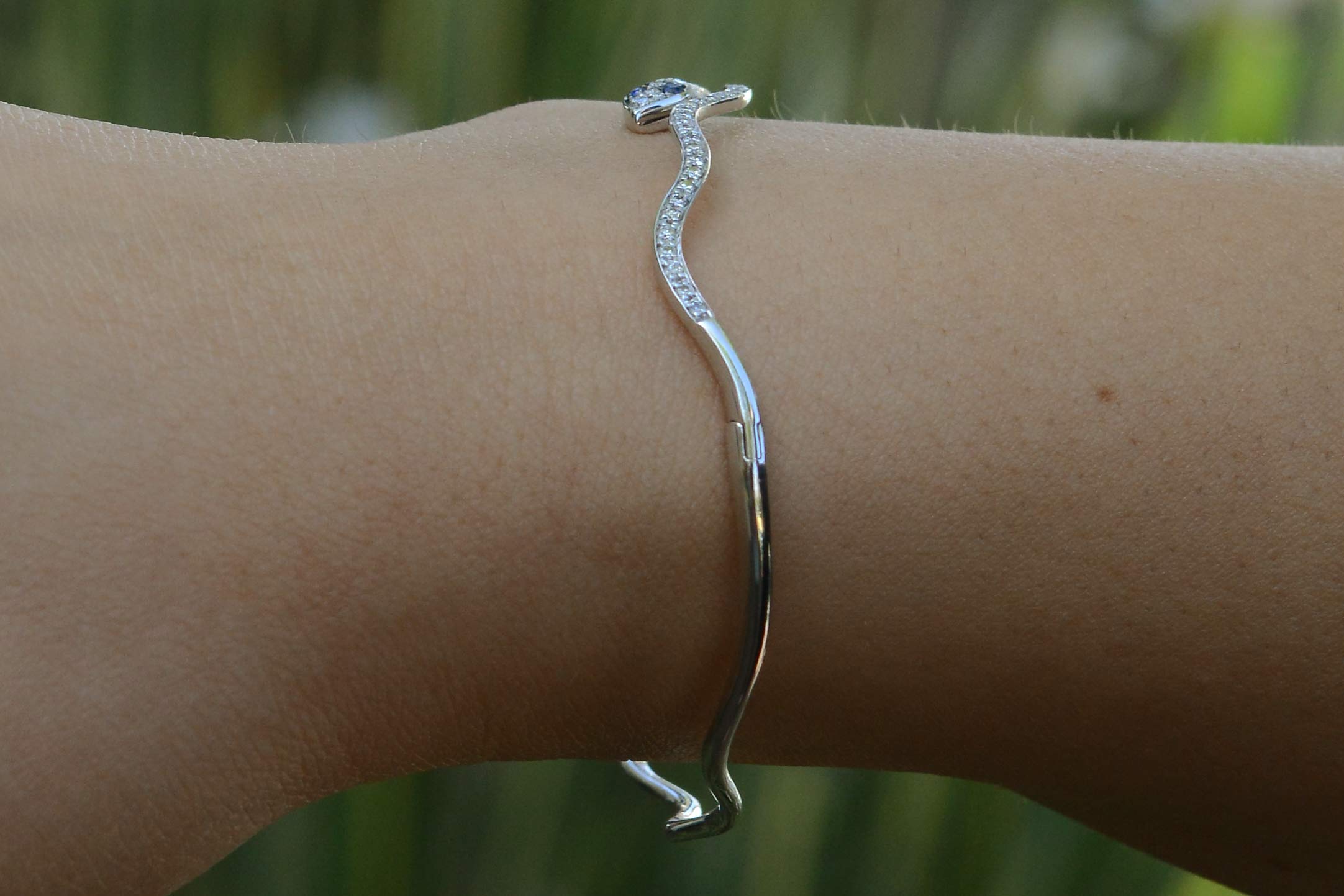 A curved white gold modern bangle bracelet.