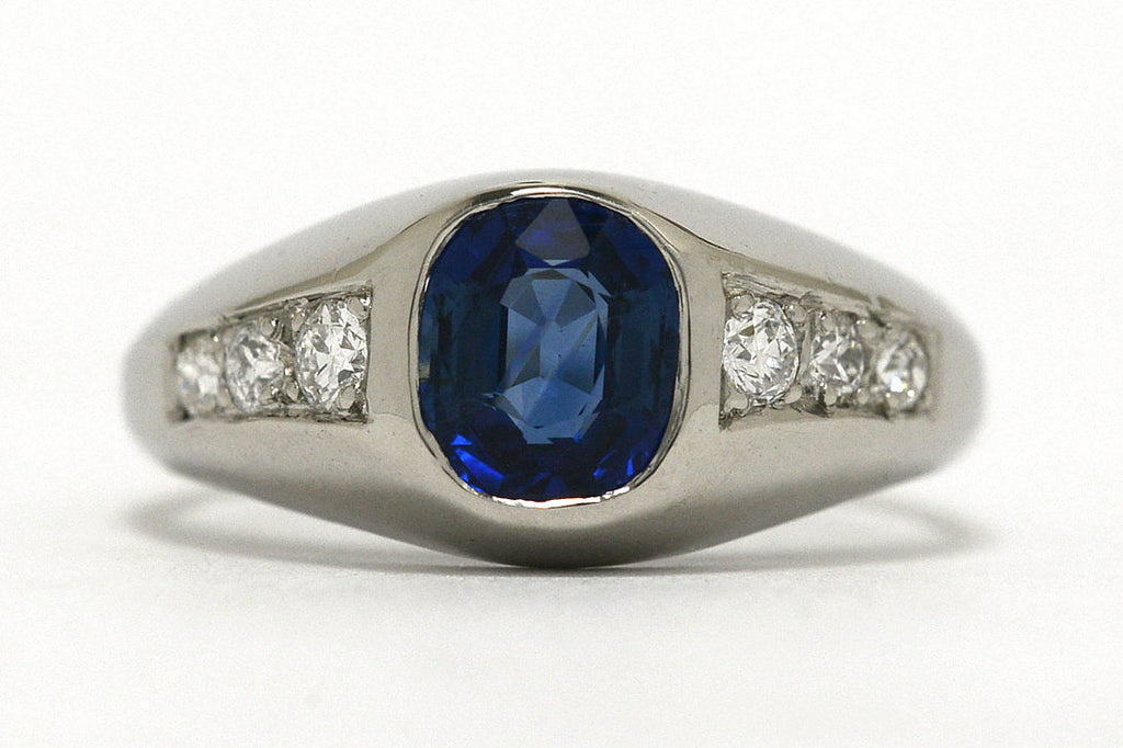 A cushion blue sapphire ring with 3 diamonds to both sides.
