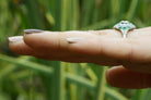 An Art Deco 1920s round diamond and cabochon cut emeralds ring.