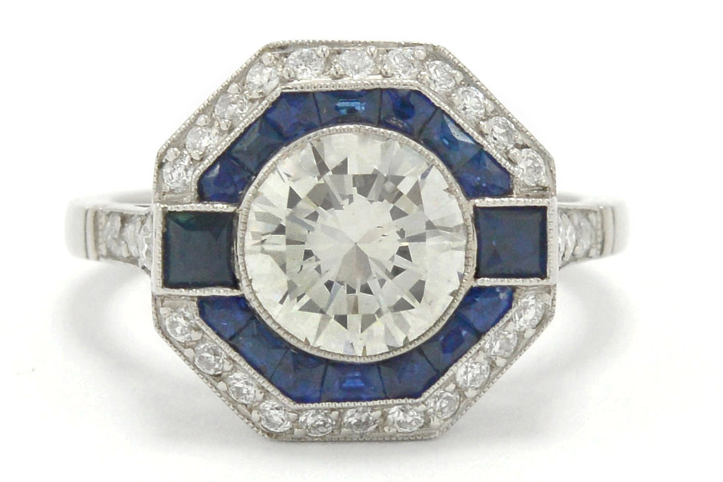 A round diamond with French and calibre cut sapphires engagement ring.