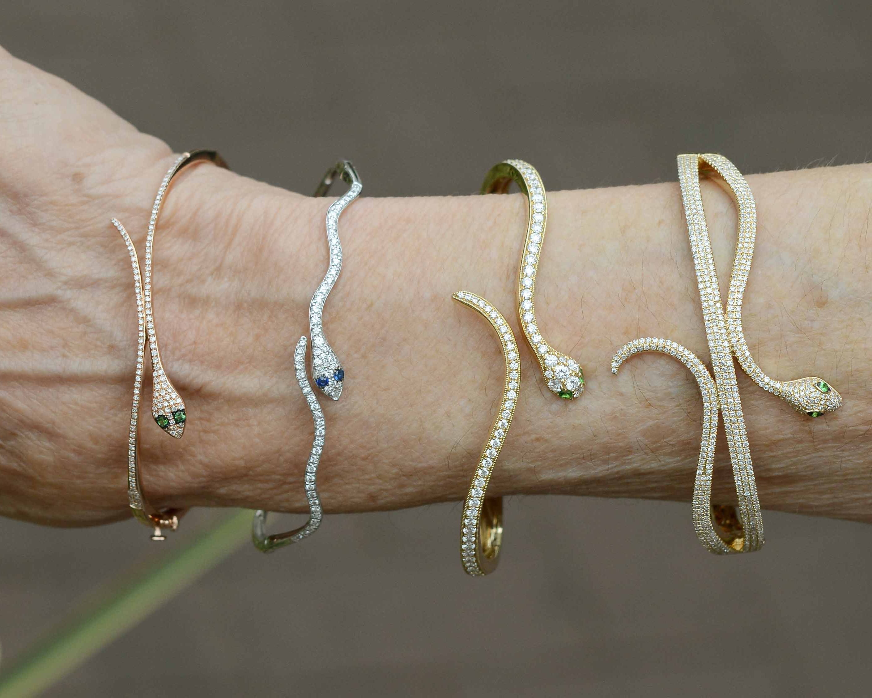 Four diamond and gold modern snake bangle bracelets.