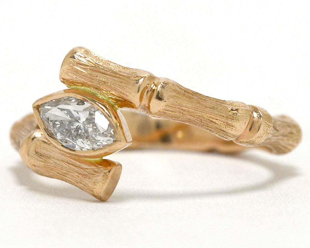 A rose gold diamond bamboo pattern solitaire ring.