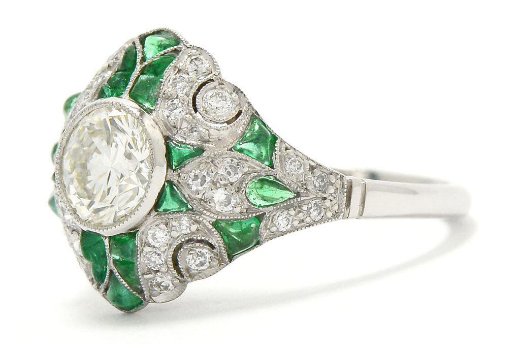 A nearly 1 carat transitional round diamond emerald engagement ring.