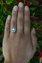 A diamond and emerald star design platinum engagement ring.