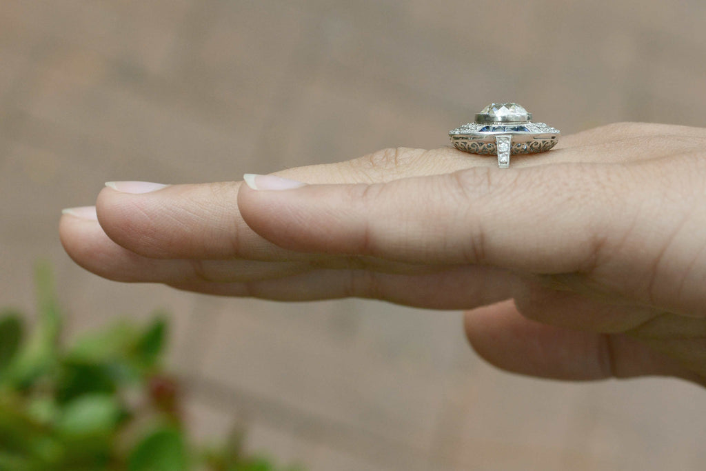 French cut blue sapphires and round diamonds accent the main gem.