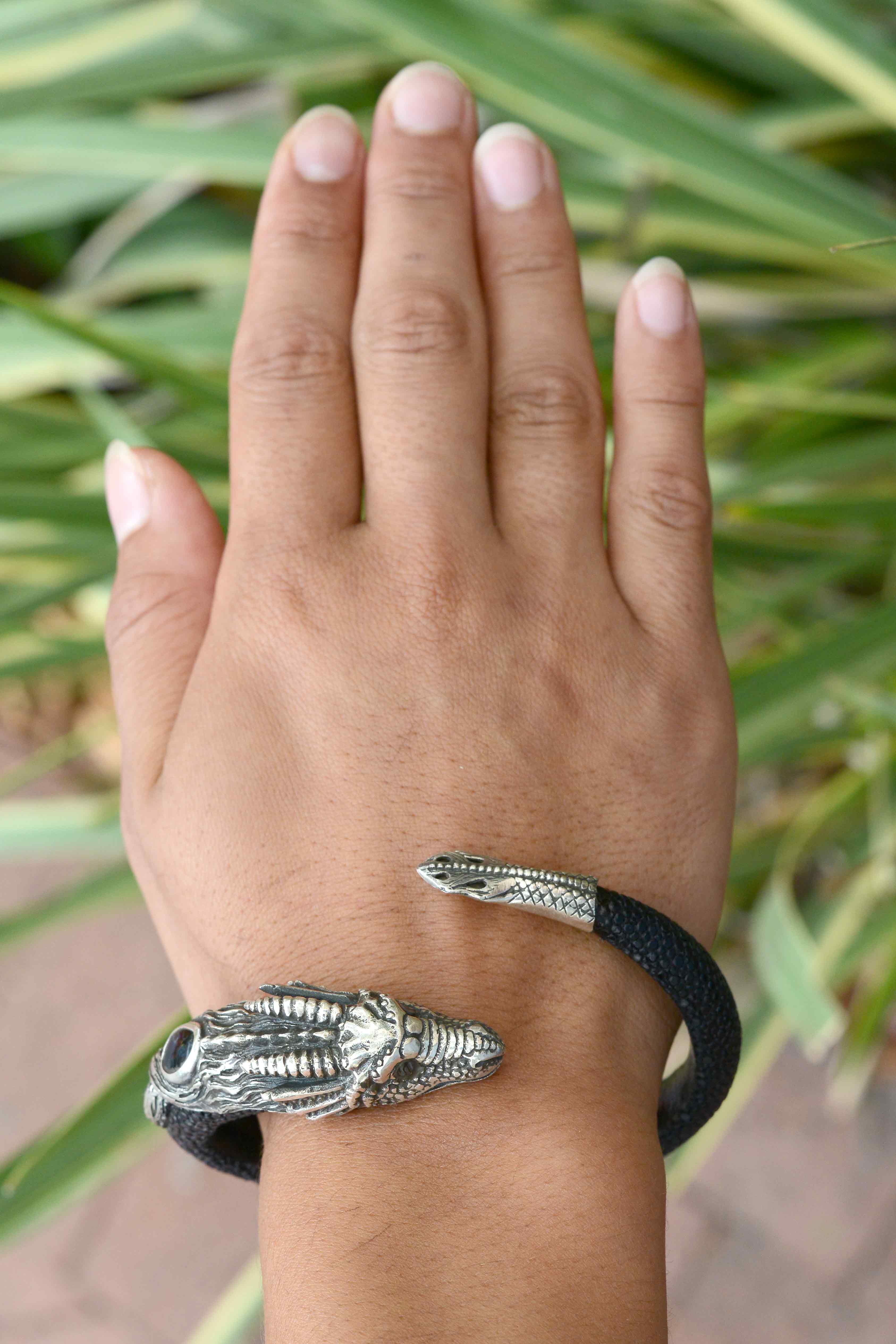 A silver dragon cuff lined with black stingray leather.