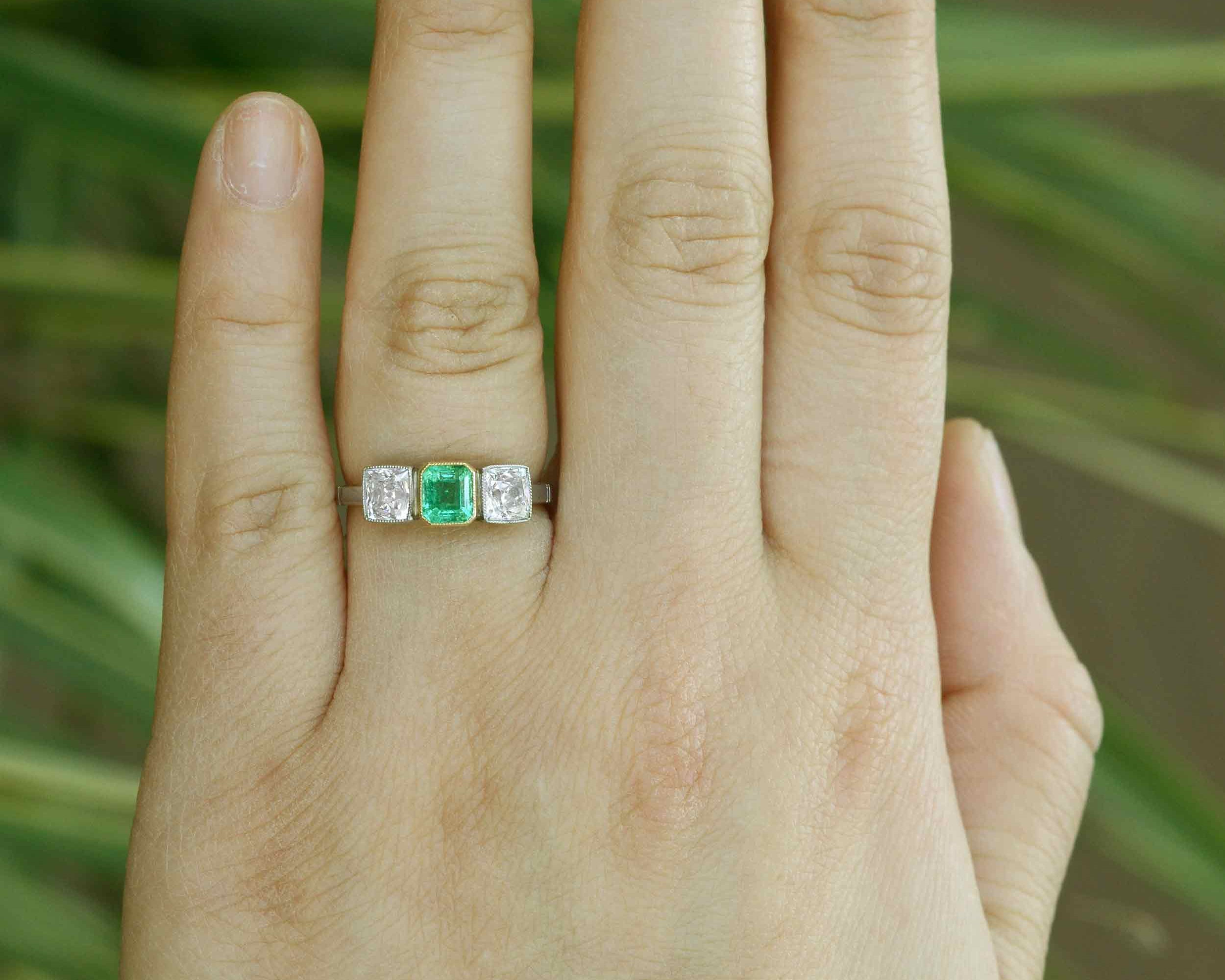 Platinum gemstone and two diamonds engagement ring.