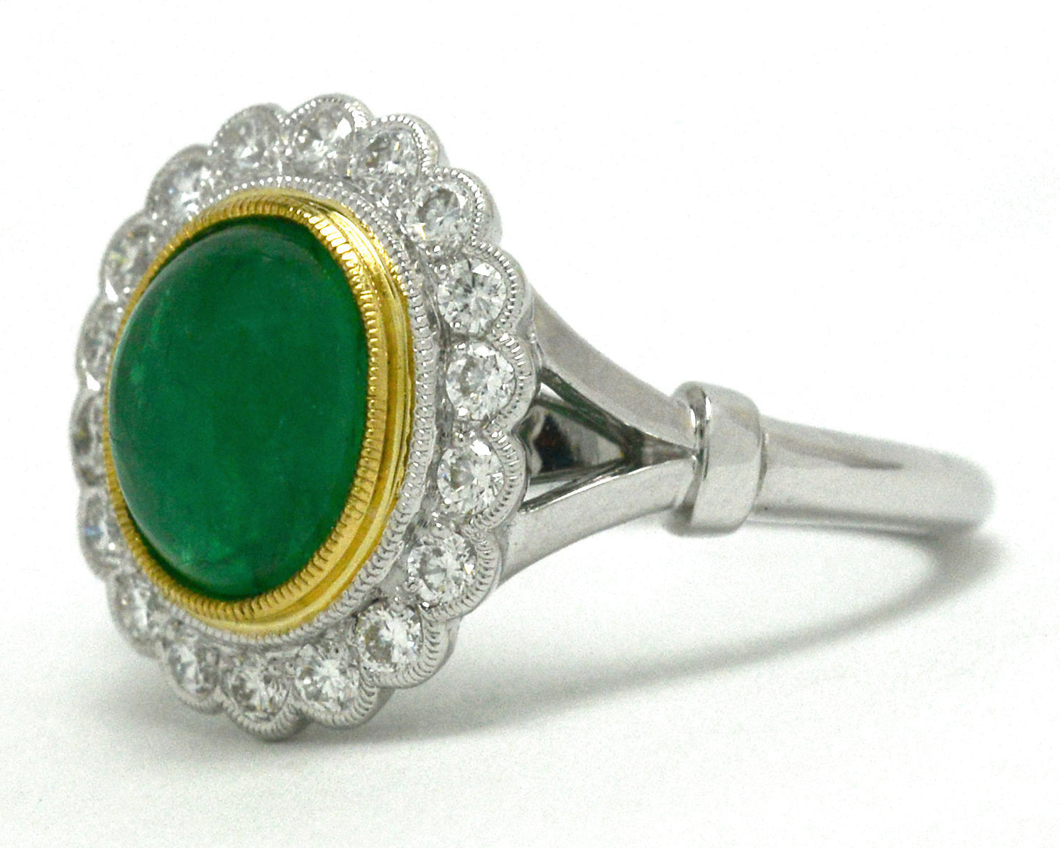 A 2 tone 18k gold bezel set emerald engagement ring.
