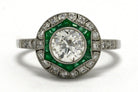 An old mine brilliant diamond, Art Deco style engagement ring with an emerald halo.