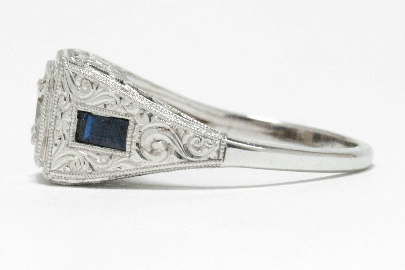Engraved white gold scrolls on the side of this diamond blue sapphire engagement ring.