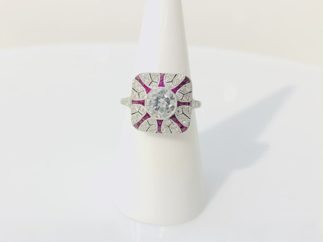 A 1 carat round brilliant diamond engagement ring has a ruby striped design.
