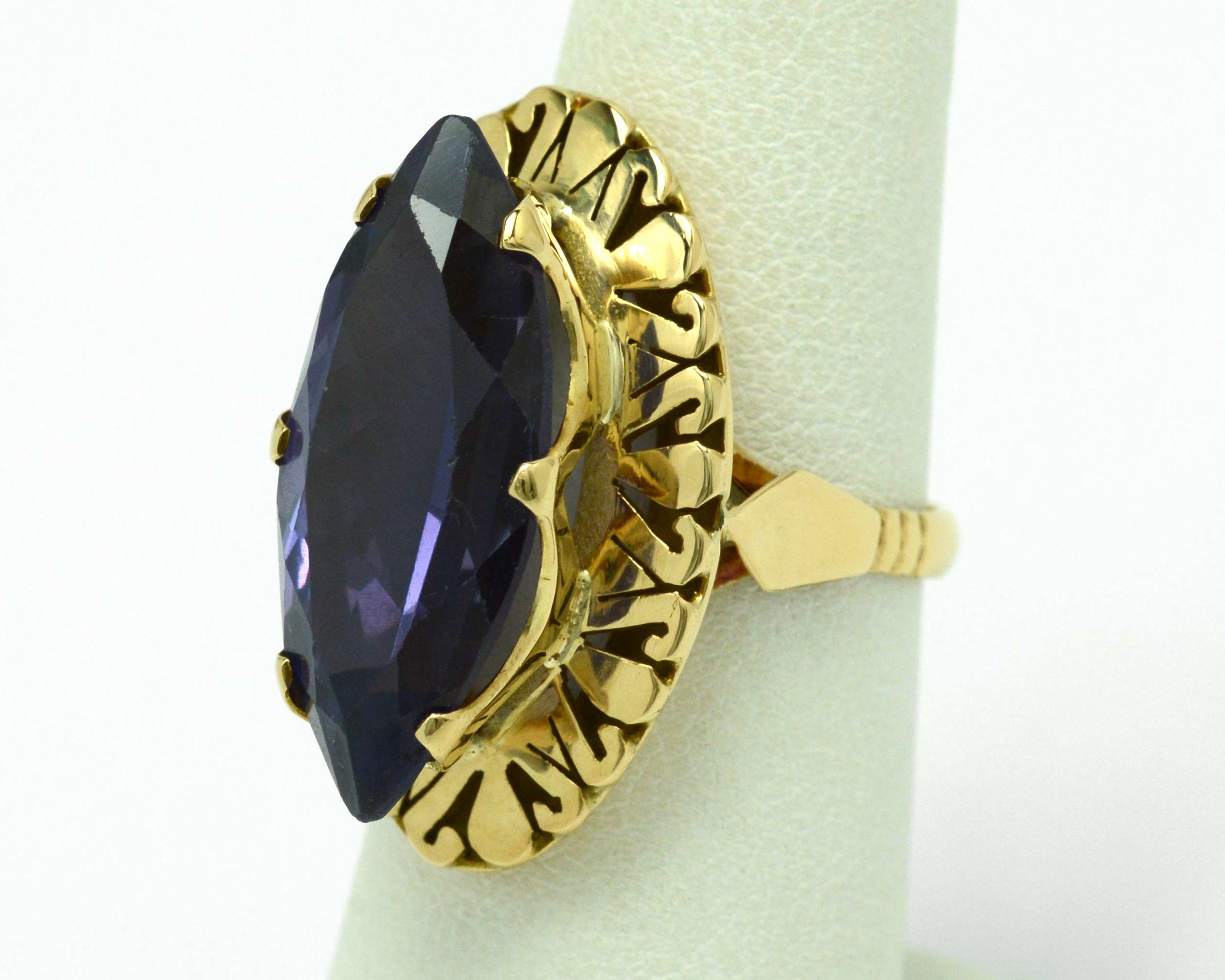 A long navette shaped amethyst ring with filigree gold accents underneath.