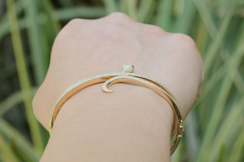 A narrow modern bangle bracelet made of 14k yellow gold.