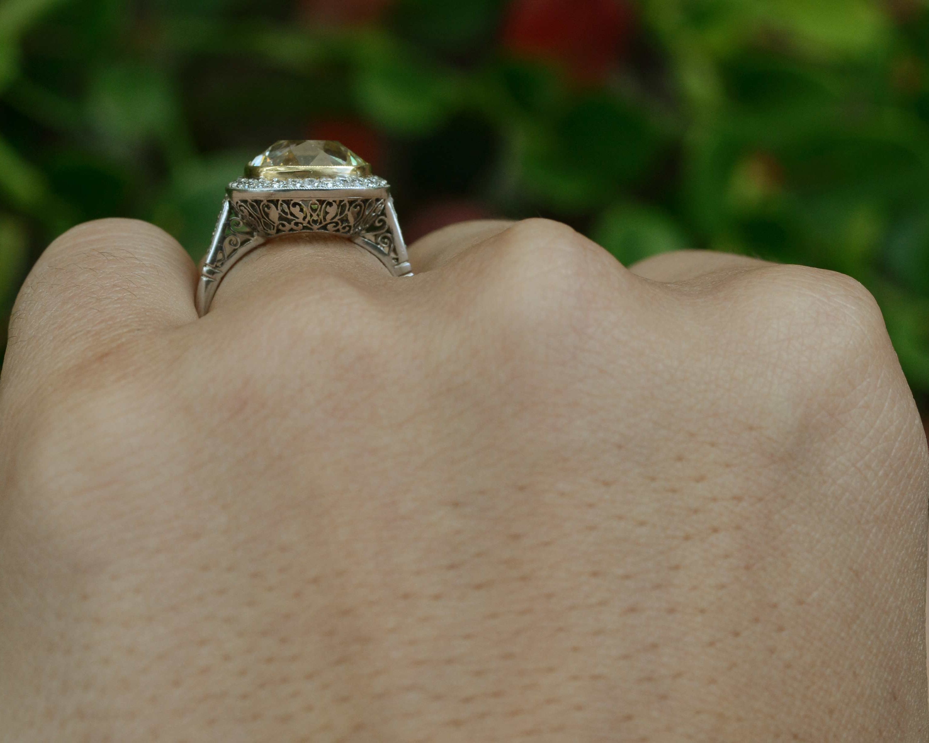 A giant five carat light yellow cushion diamond, set in a filigree engagement ring design.