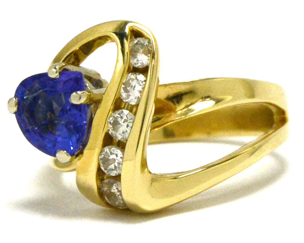 An asymmetrical 14k gold ring design with a trillion cut tanzanite.