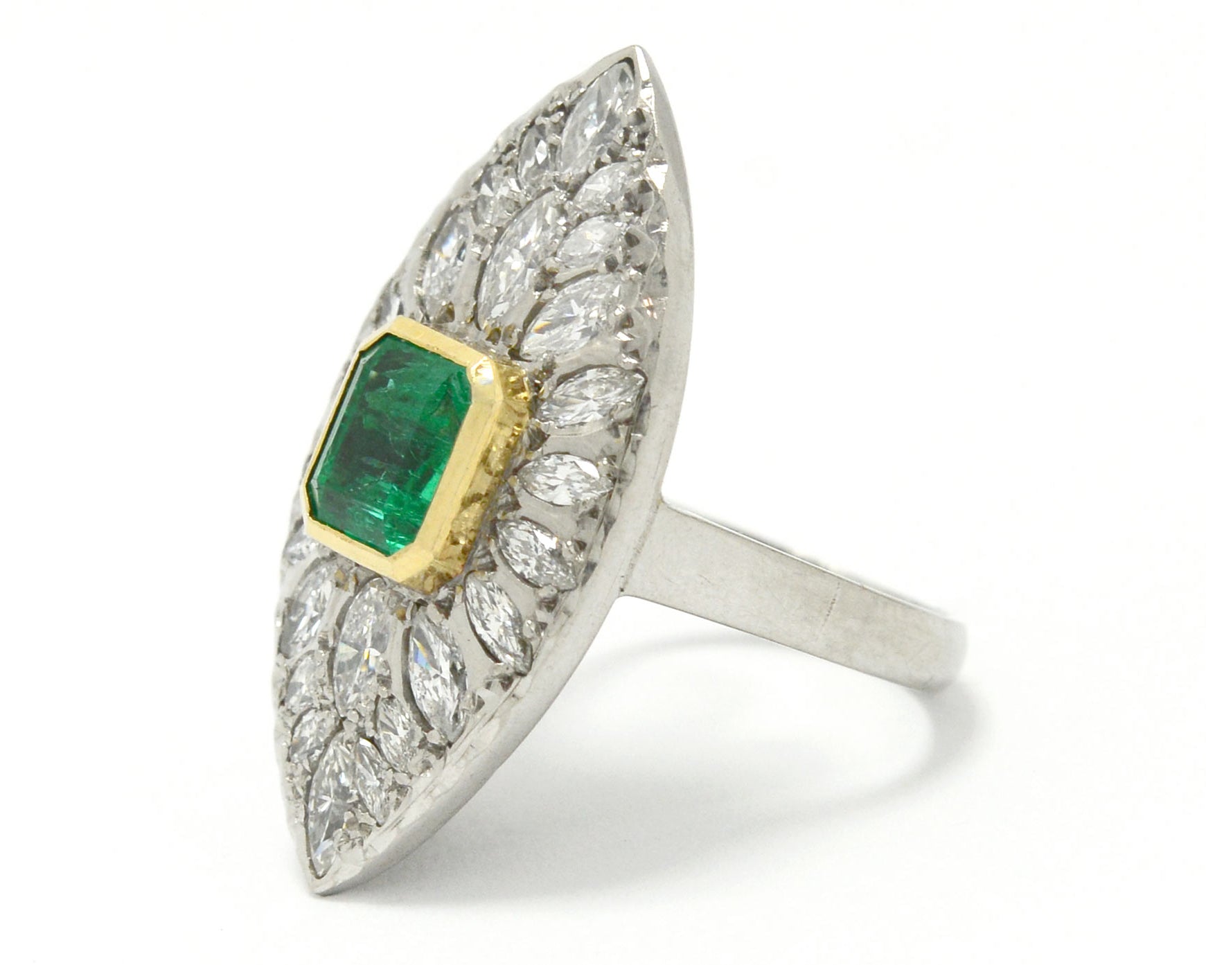 An 18k yellow gold bezel supports the two carat emerald in this stunning cluster statement ring.