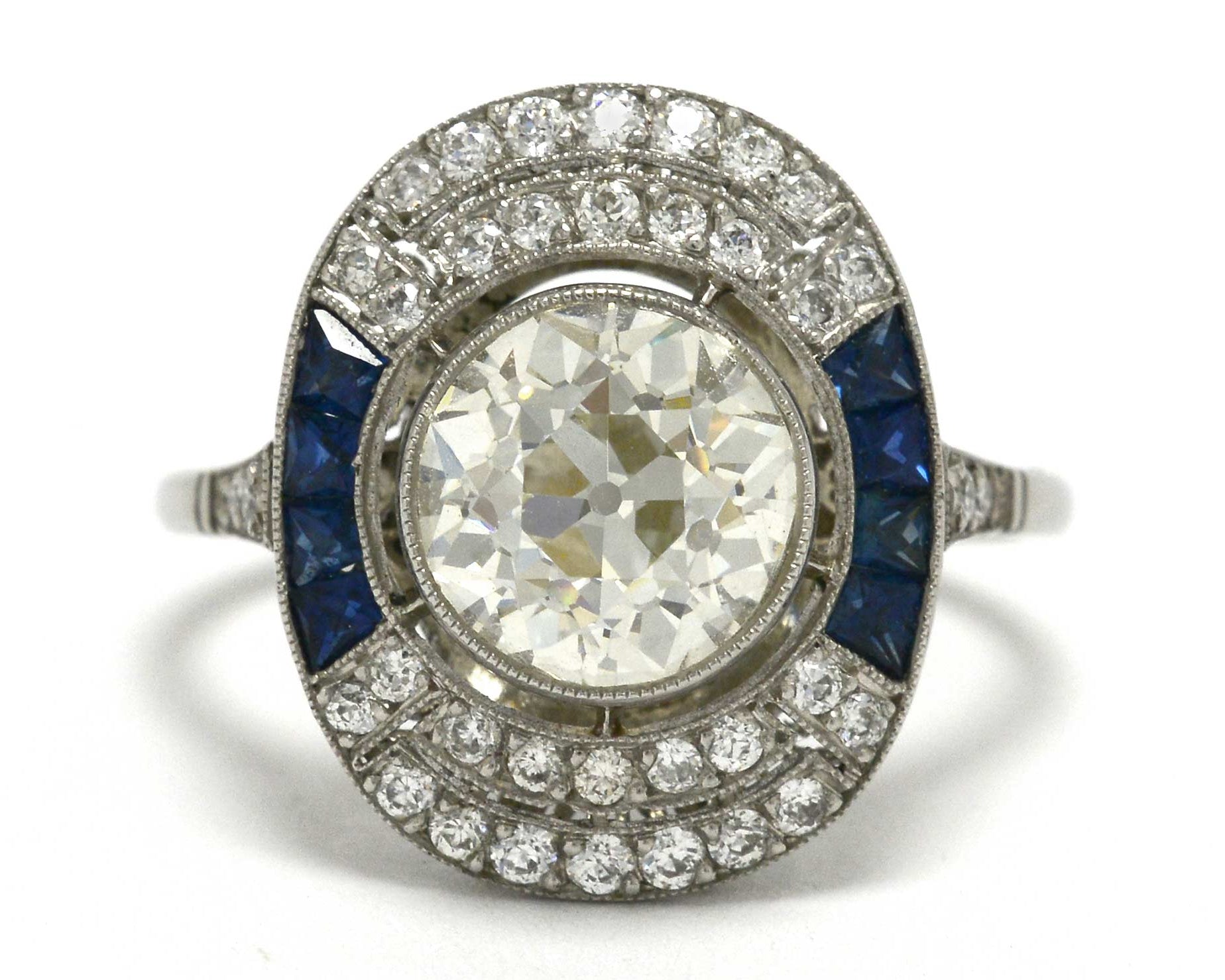 An old mine brilliant diamond cocktail ring with blue sapphire sides.
