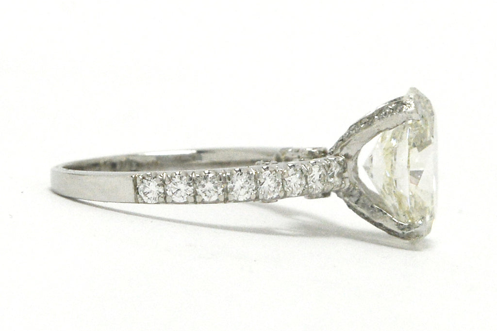 Diamonds are on the straight band of this solitaire wedding ring.