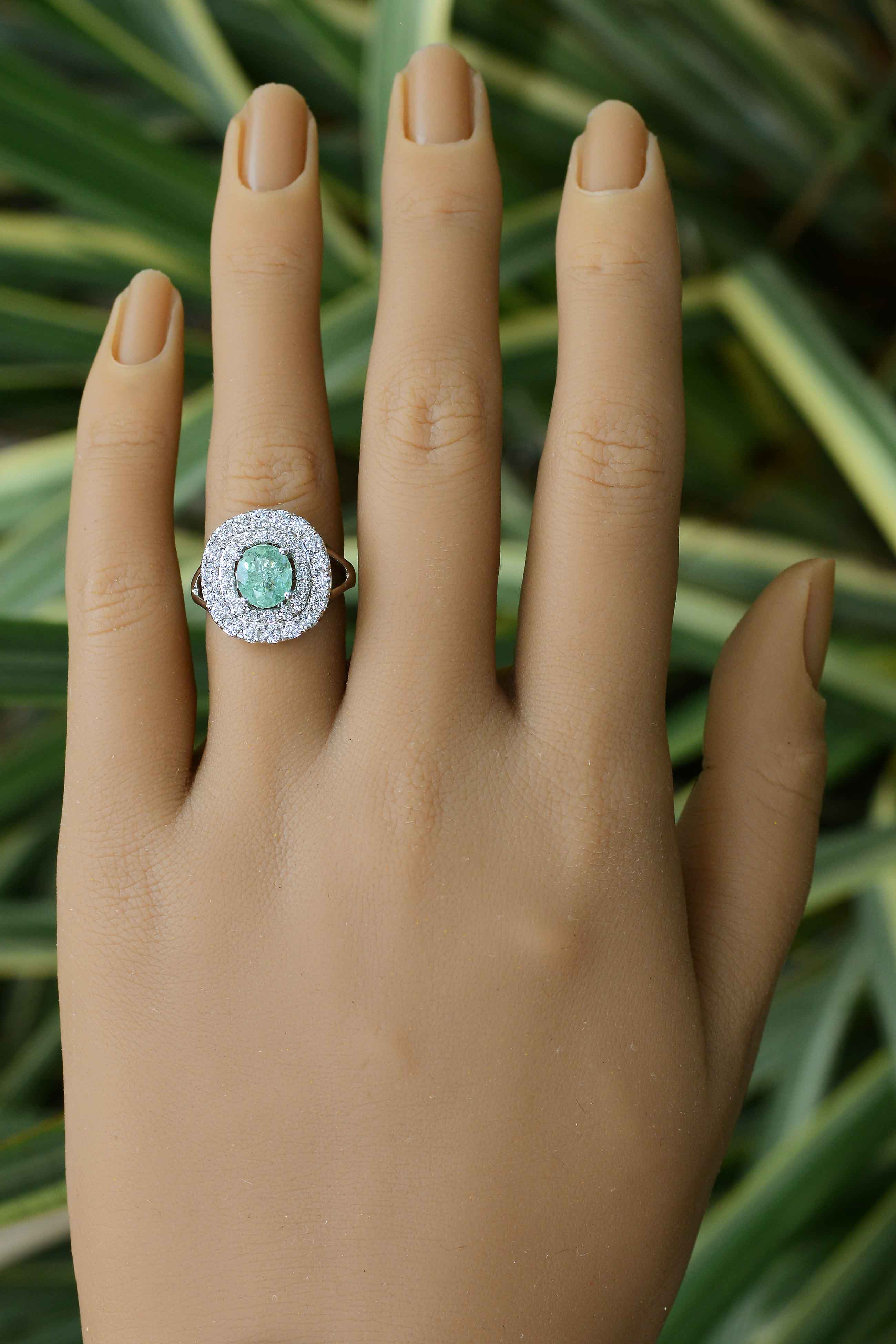 The central gem is certified by the Gemological Institute Laboratories as natural Paraiba and of a captivating, bluish, sea-foam green.