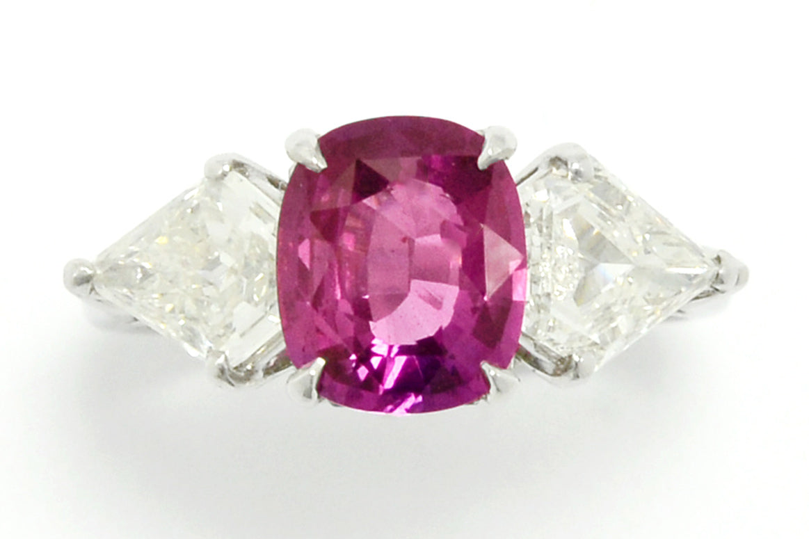 A heated, natural 2 carat cushion cut pink sapphire engagement ring.