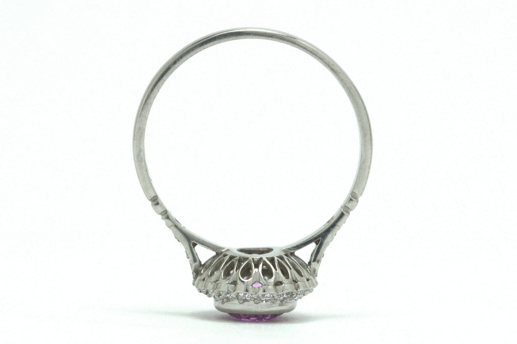 A platinum foliate scrolled under-crown engagement ring. 