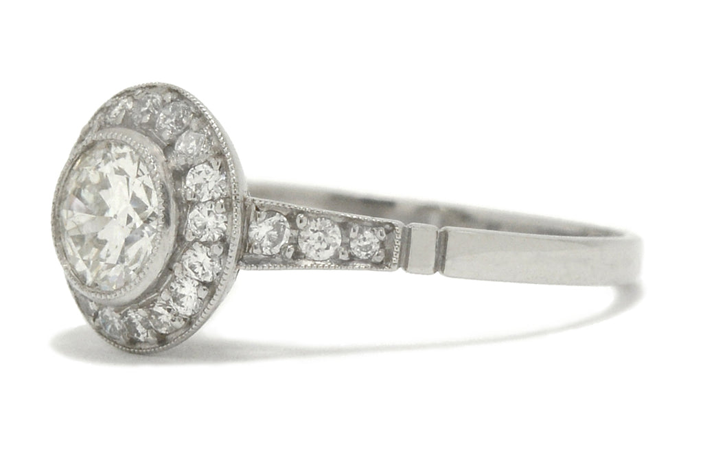 A round, old European diamond is surrounded by a halo in this engagement ring.