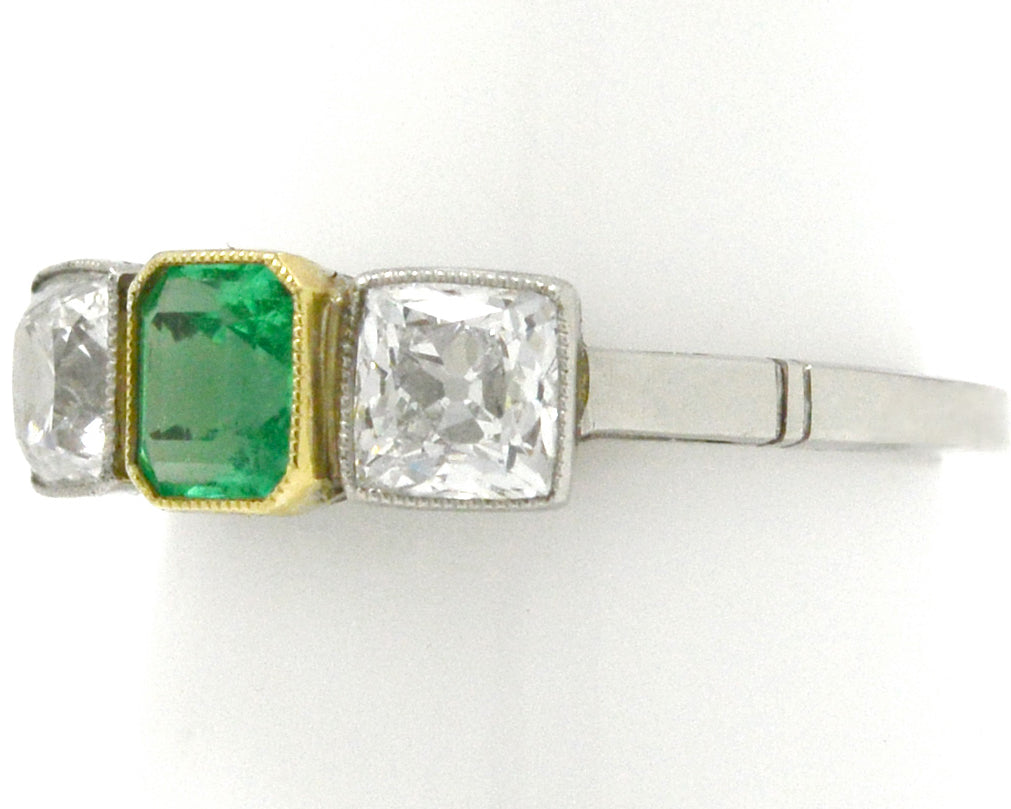 An early 1900s Art Deco emerald and diamond three stone ring design.