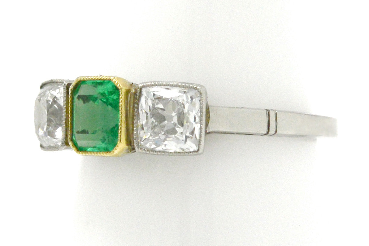 An early 1900s Art Deco emerald and diamond three stone ring design.