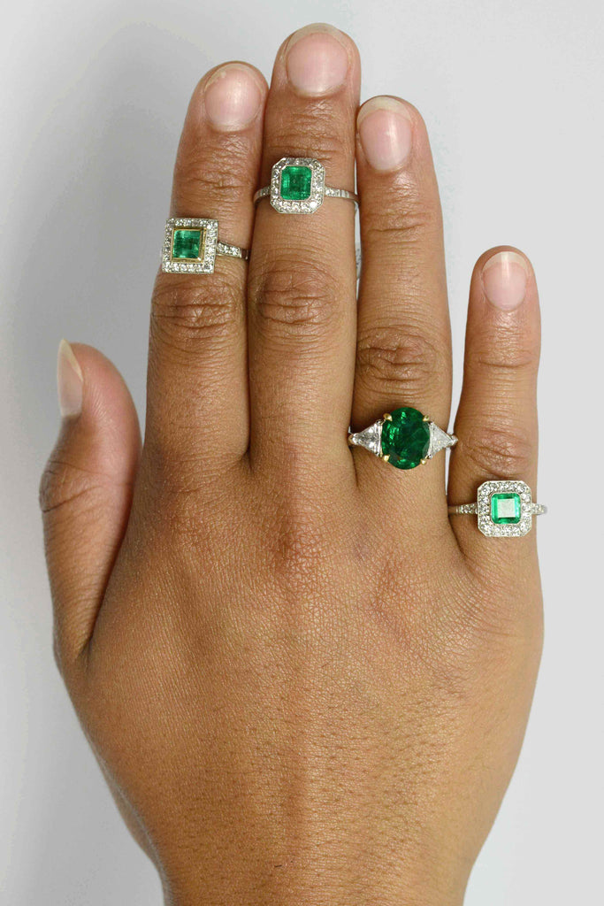 A collection of emerald and diamonds halo engaement rings.