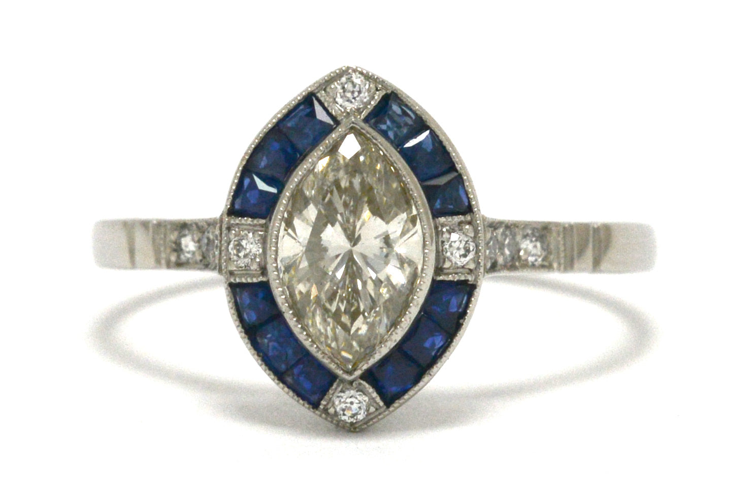 An Art Deco inspired marquise cut diamond engagement ring with a sapphire halo.
