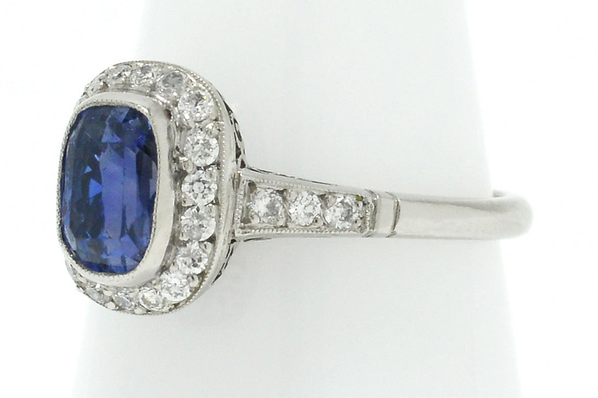 Old European diamonds line the 3 carat unheated sapphire in this halo engagement ring.