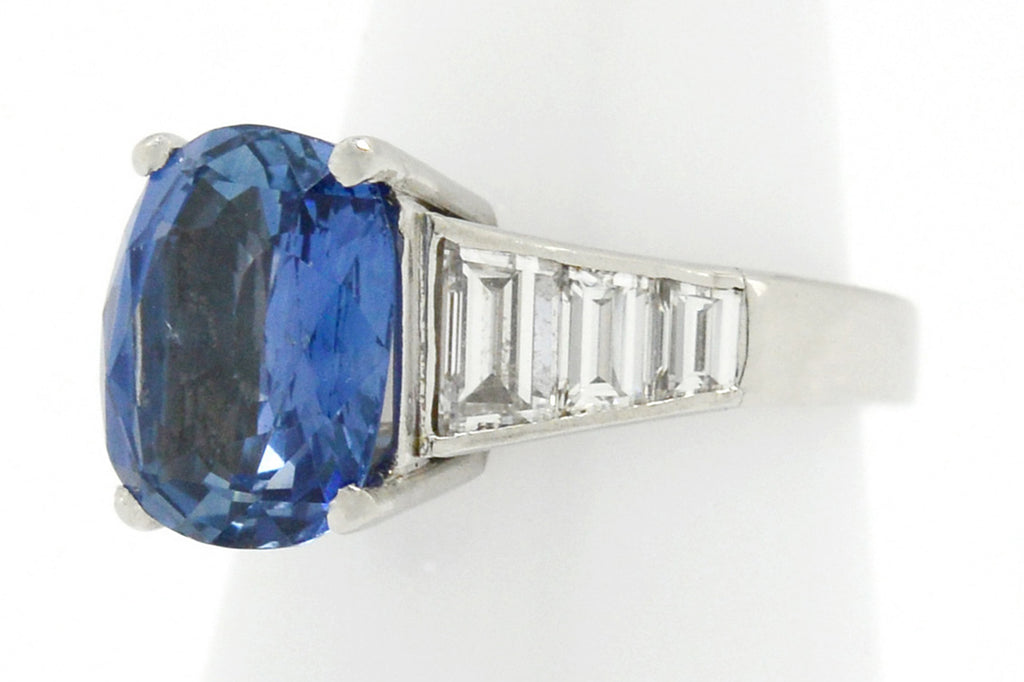 An unheated large oval ceylon sapphire engagement ring with 6 diamonds on the band.