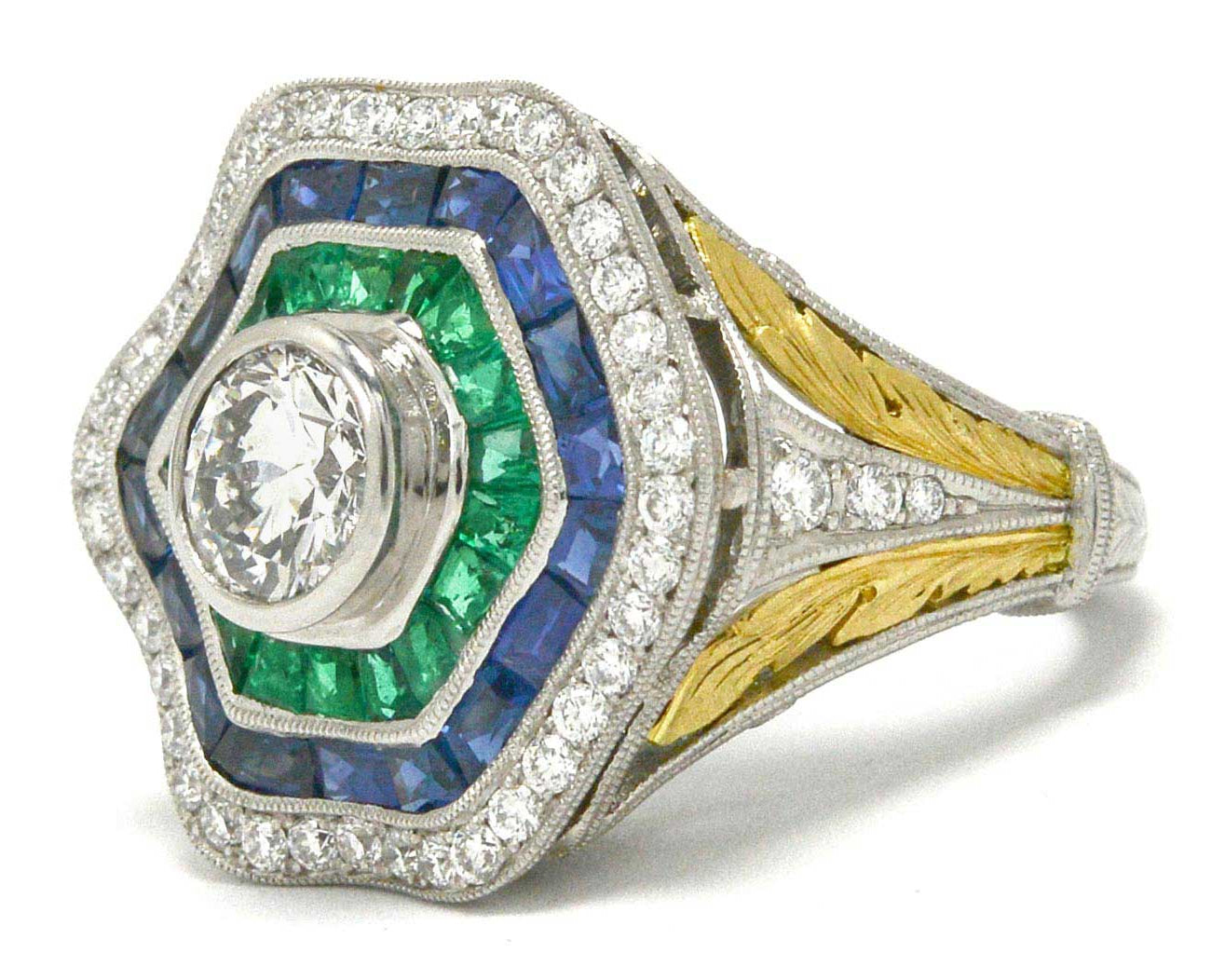 A 1 carat round brilliant diamond hexagon ballerina ring with emeralds and sapphires.