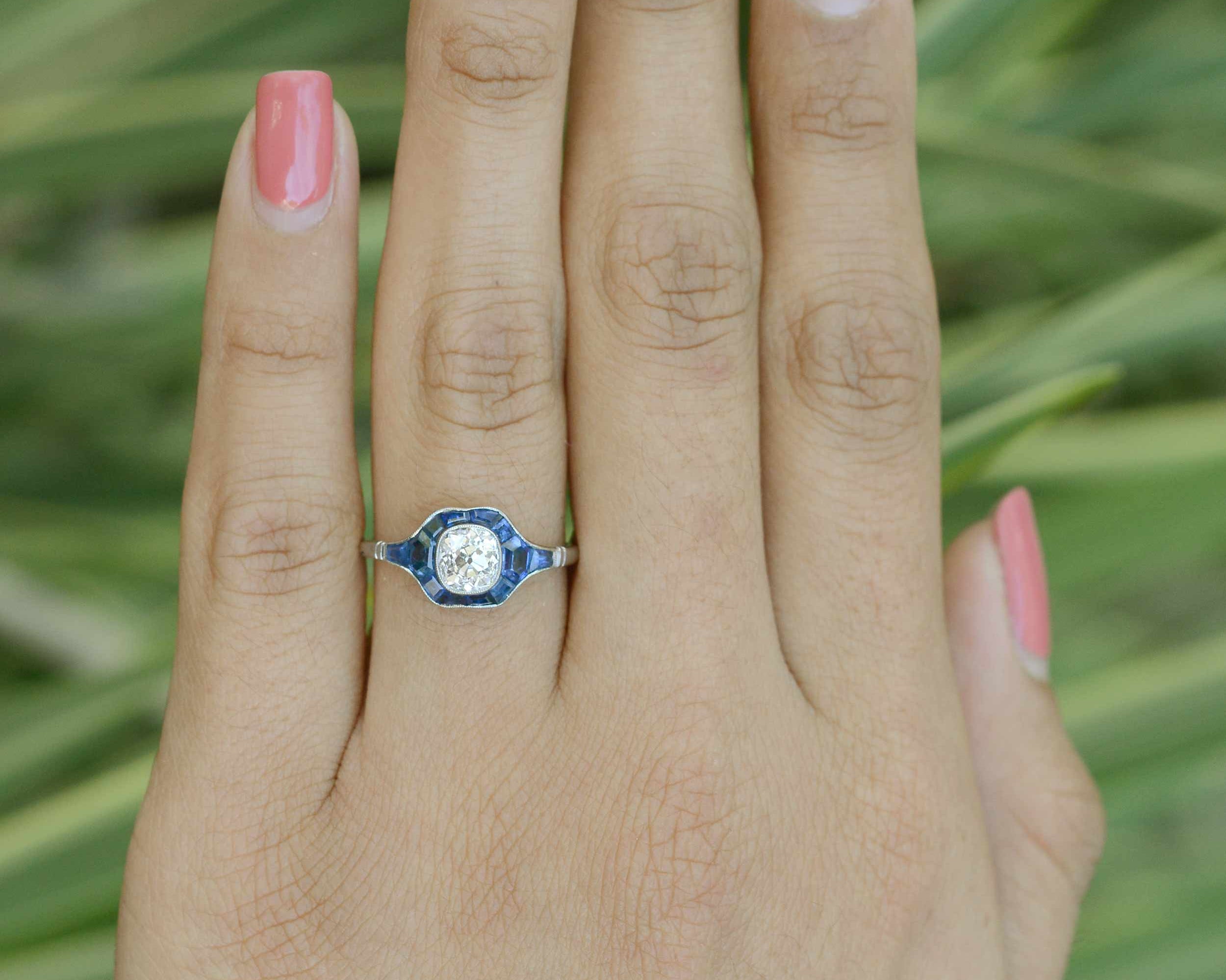 This diamond and blue sapphire bridal ring has a milgrain bezel setting.