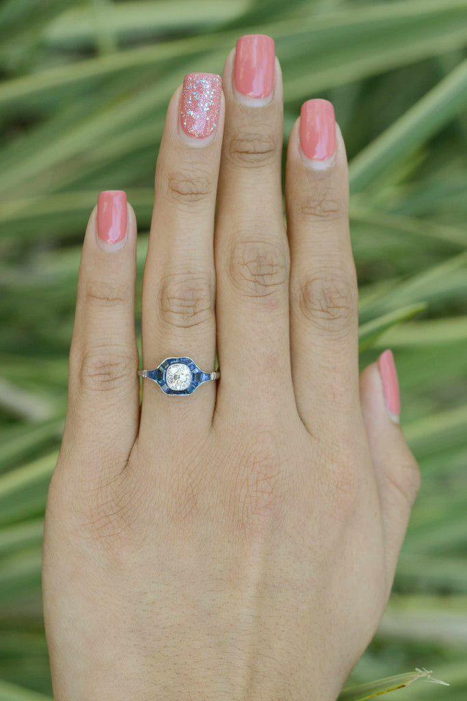 This diamond and blue sapphire bridal ring has a milgrain bezel setting.