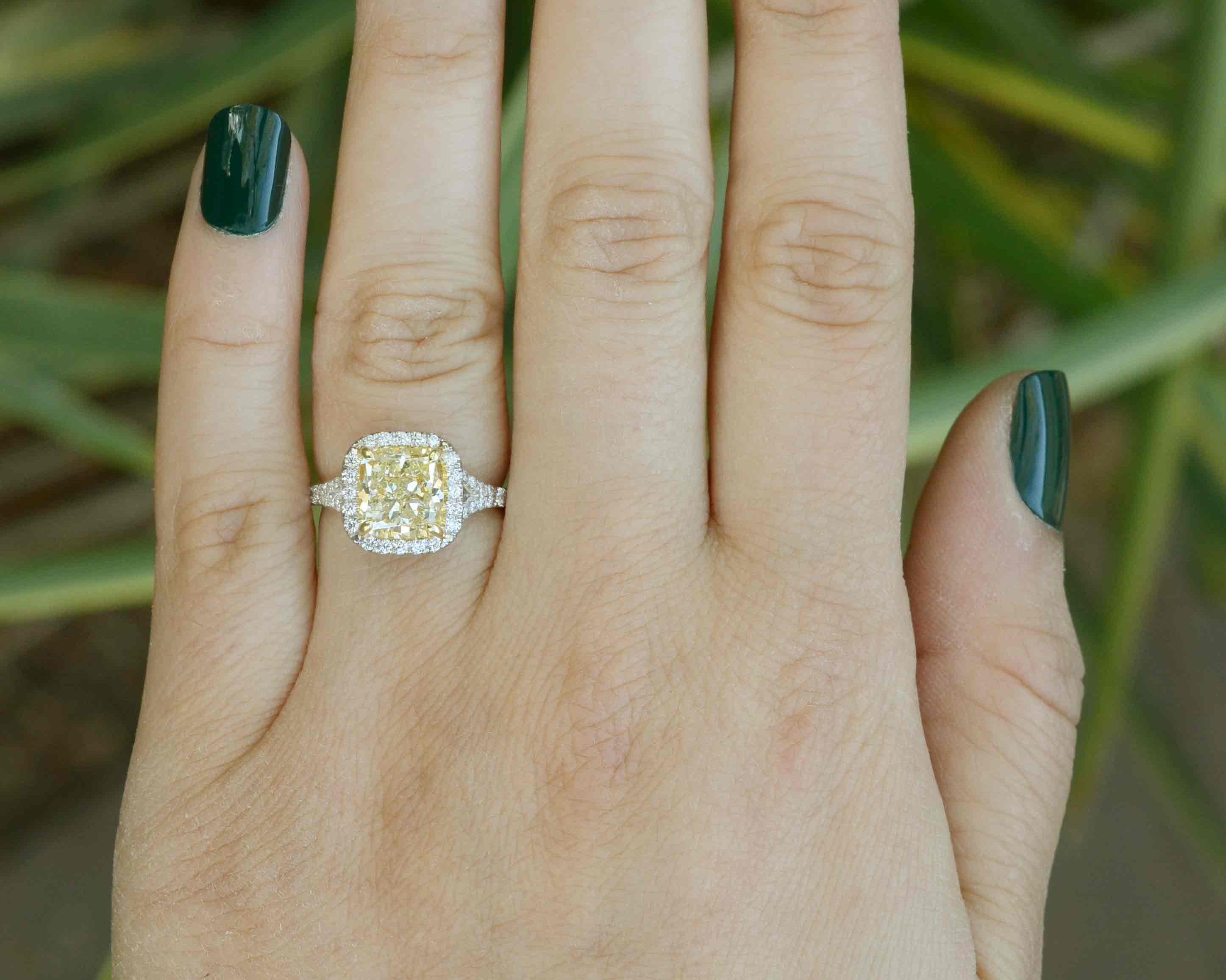 The 3.14 carat yellow diamond displays w - x color with vs2 clarity in this modern engagement ring.